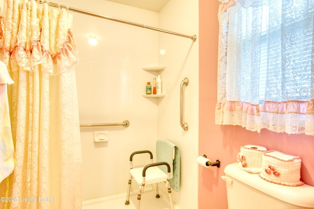 bathroom featuring walk in shower and toilet