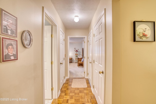 hall featuring light parquet flooring and a textured ceiling