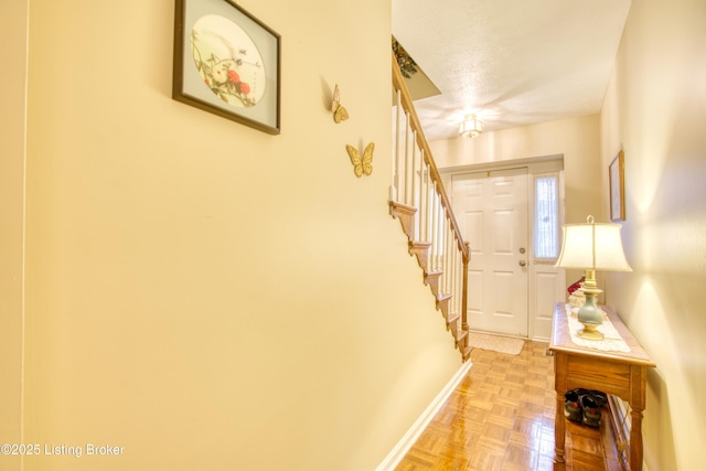 foyer entrance featuring light parquet flooring and a textured ceiling