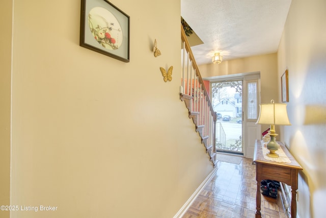 foyer with parquet flooring and a textured ceiling