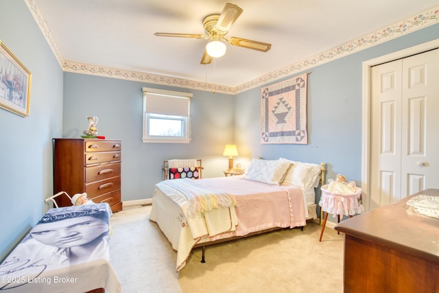 bedroom featuring ceiling fan, a closet, and light carpet