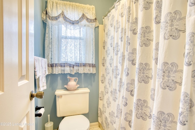 bathroom featuring walk in shower and toilet