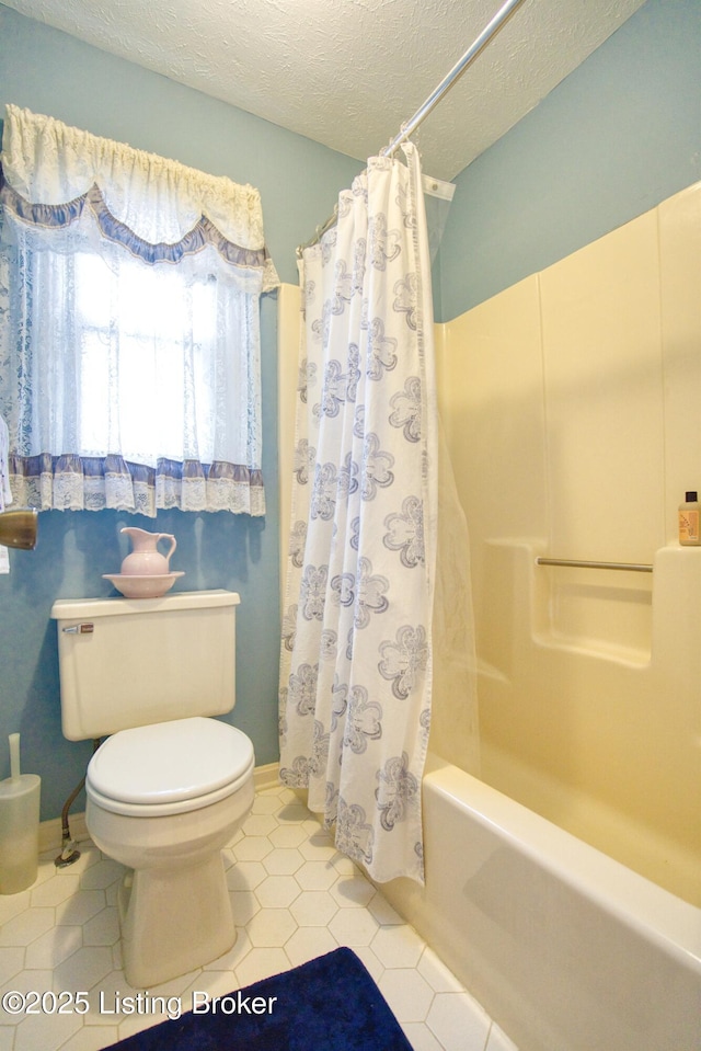 bathroom featuring a textured ceiling, tile patterned floors, toilet, and shower / bath combo with shower curtain