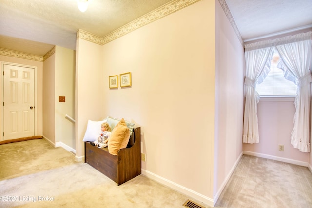 hallway with light carpet and a textured ceiling