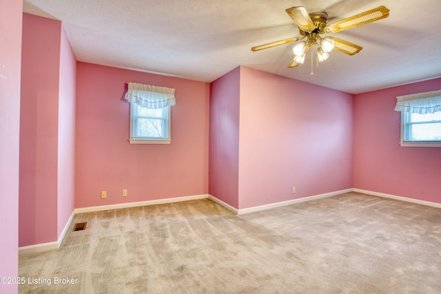 carpeted empty room featuring ceiling fan and a textured ceiling