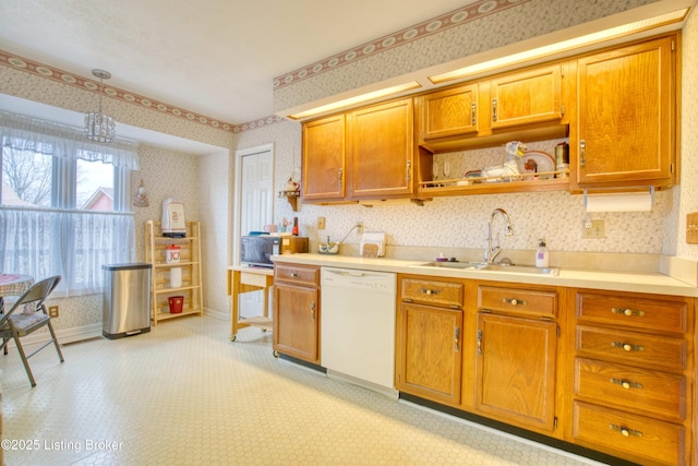 kitchen with sink, white dishwasher, and decorative light fixtures