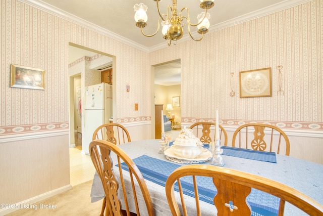 dining room featuring ornamental molding, light colored carpet, and an inviting chandelier