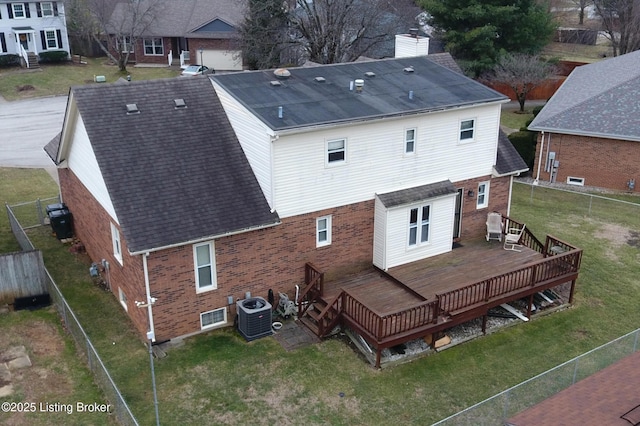 rear view of house with cooling unit, a yard, and a deck