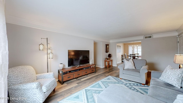 living room featuring hardwood / wood-style flooring and ornamental molding