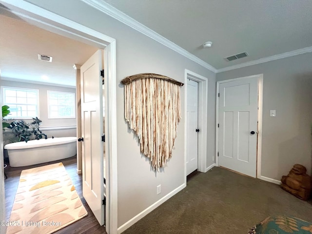 hall featuring crown molding and dark carpet