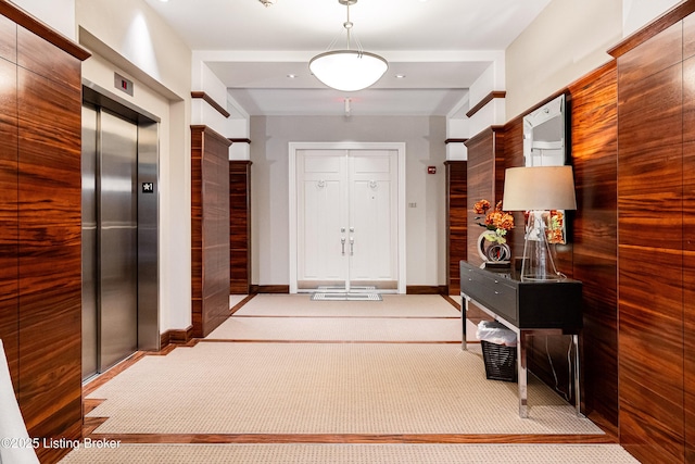 hallway featuring light carpet and elevator