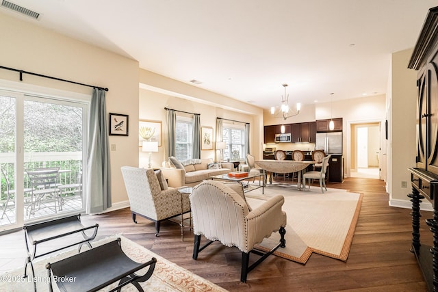 living room with dark hardwood / wood-style floors and a chandelier