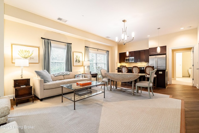 living room with light hardwood / wood-style flooring and a notable chandelier