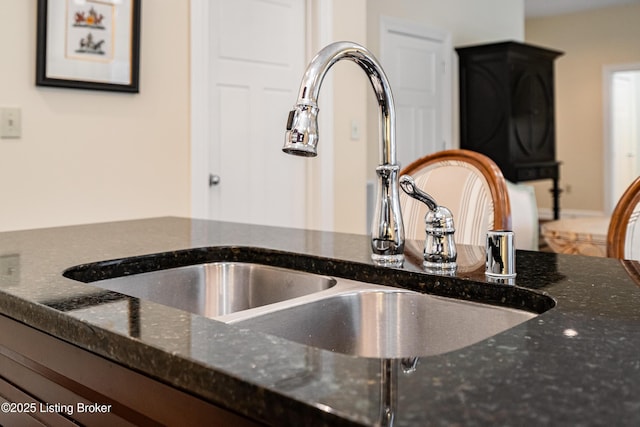 room details with dark stone countertops and sink