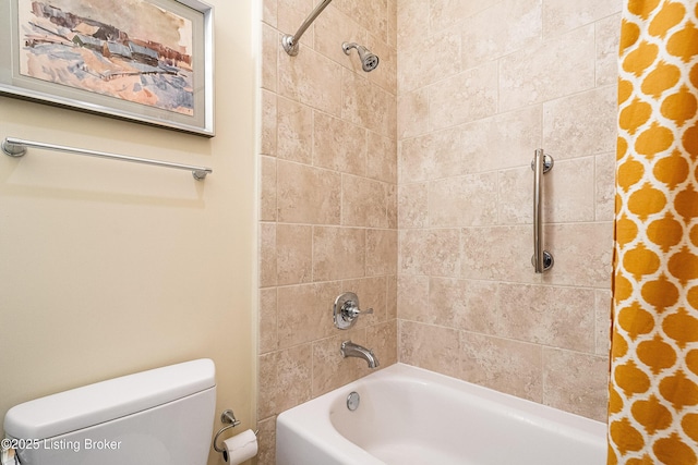 bathroom featuring tiled shower / bath and toilet