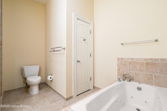 bathroom featuring tile patterned flooring, a tub, and toilet