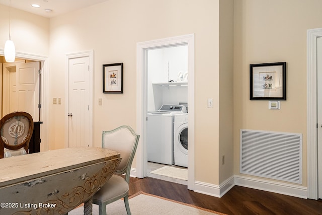 laundry area featuring washer and clothes dryer and dark wood-type flooring