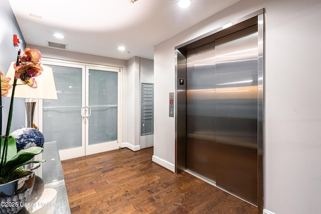 interior space with mail boxes, dark hardwood / wood-style floors, and elevator