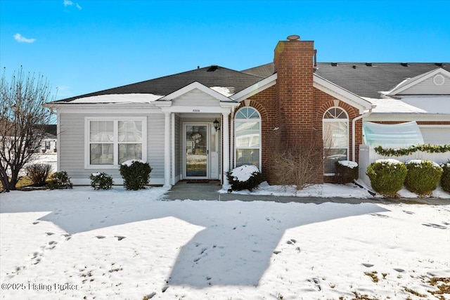 view of front of house featuring brick siding and a chimney