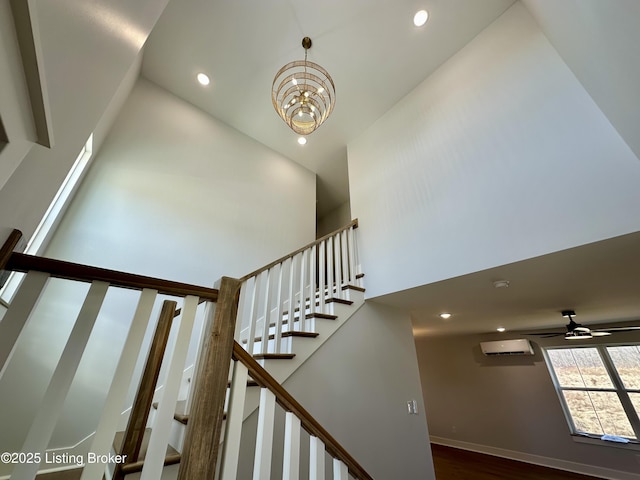 stairs featuring a high ceiling, a wall mounted AC, and an inviting chandelier