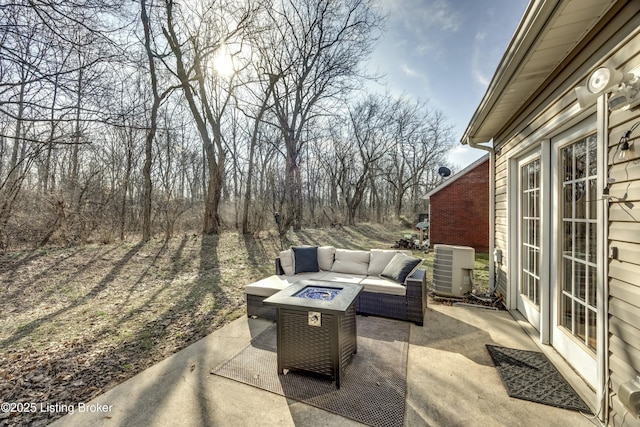 view of patio / terrace featuring central AC unit and an outdoor living space with a fire pit