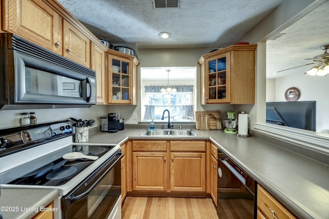 kitchen featuring sink, black appliances, light hardwood / wood-style floors, a textured ceiling, and ceiling fan with notable chandelier