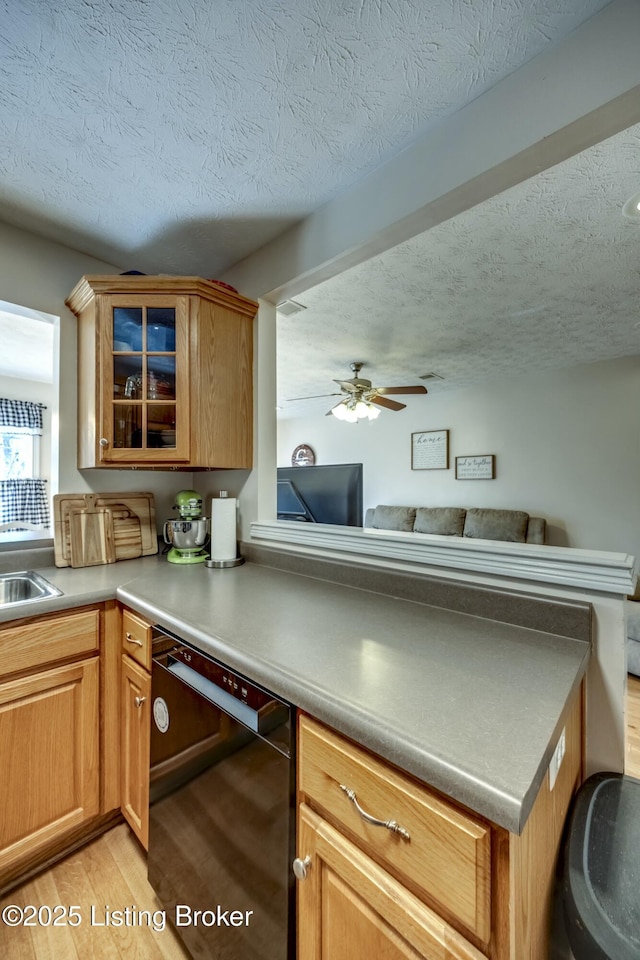 kitchen featuring ceiling fan, black dishwasher, light hardwood / wood-style flooring, and a textured ceiling