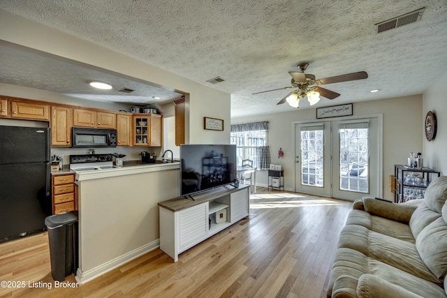 kitchen with ceiling fan, light hardwood / wood-style floors, black appliances, a textured ceiling, and kitchen peninsula