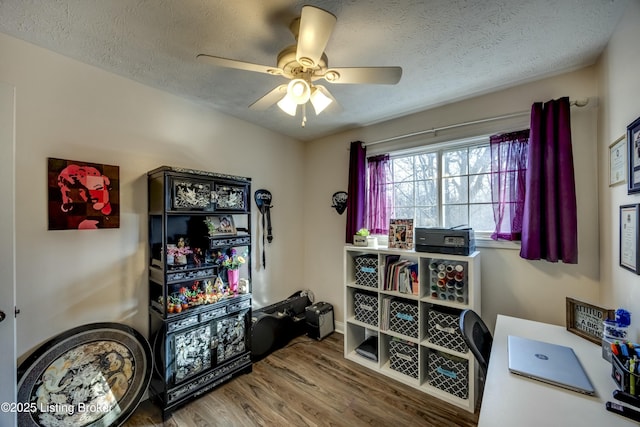 home office featuring hardwood / wood-style flooring, ceiling fan, and a textured ceiling