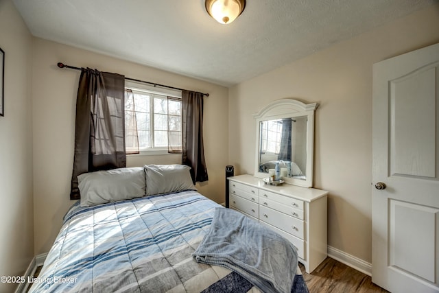 bedroom featuring hardwood / wood-style flooring and a textured ceiling