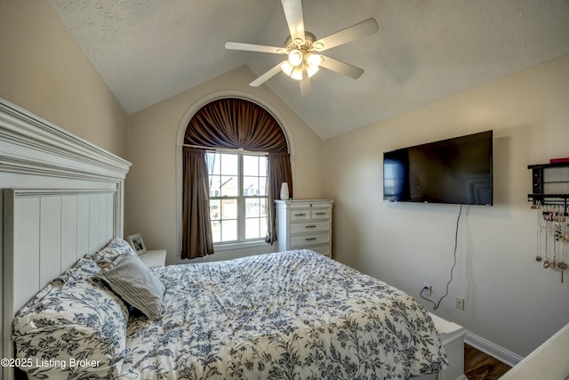 bedroom featuring ceiling fan, lofted ceiling, and a textured ceiling