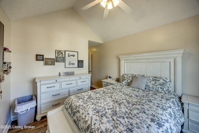 bedroom featuring dark hardwood / wood-style flooring, vaulted ceiling, and ceiling fan