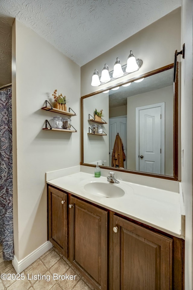 bathroom featuring vanity, tile patterned flooring, and a textured ceiling