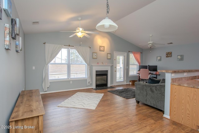 living room featuring wood-type flooring, lofted ceiling, and ceiling fan