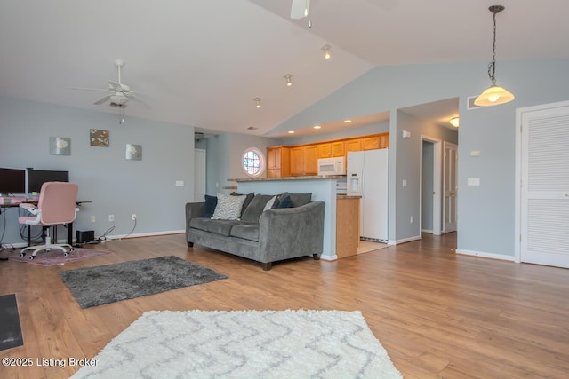 living room with ceiling fan, vaulted ceiling, and light hardwood / wood-style flooring