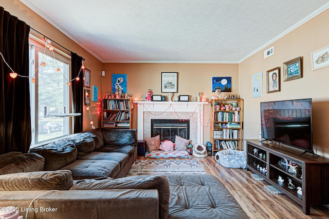 living room with crown molding, a high end fireplace, hardwood / wood-style floors, and a textured ceiling