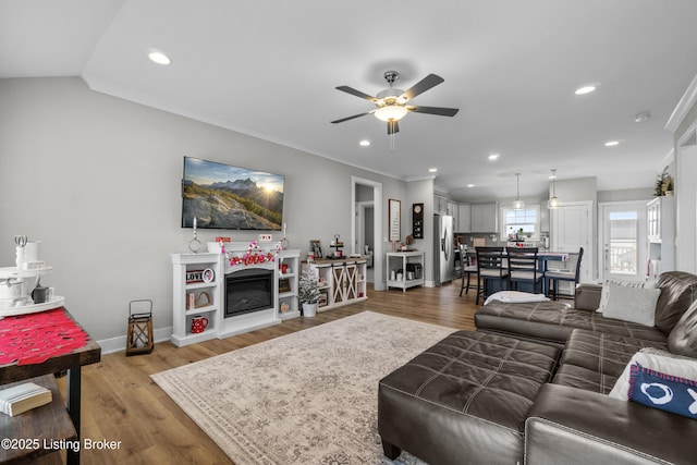 living room featuring ceiling fan, wood-type flooring, and vaulted ceiling