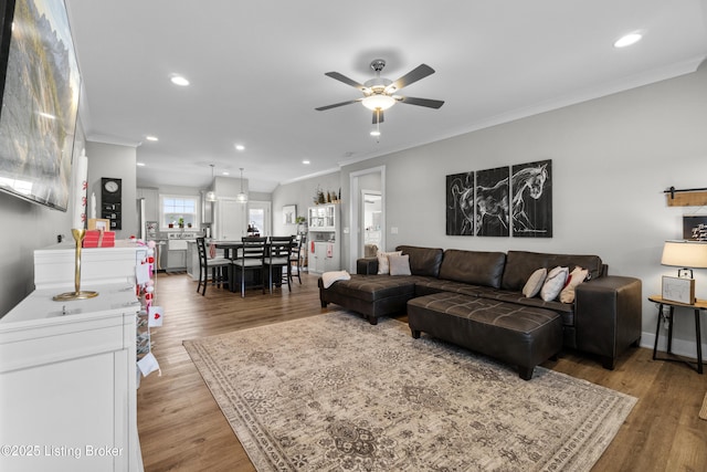 living room featuring ceiling fan, ornamental molding, and hardwood / wood-style floors