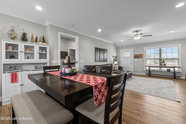 dining area featuring ceiling fan, ornamental molding, and light wood-type flooring