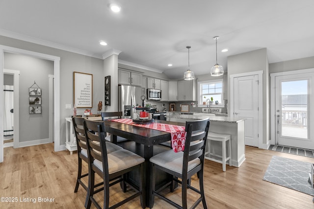 dining space featuring ornamental molding and light hardwood / wood-style floors