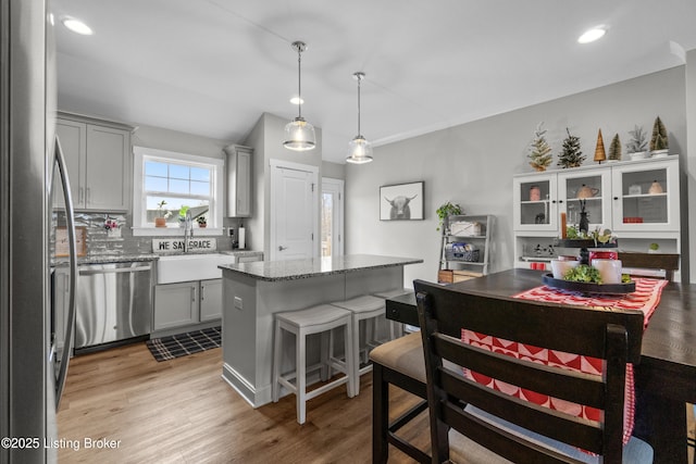 kitchen featuring gray cabinetry, pendant lighting, stainless steel appliances, and a kitchen island