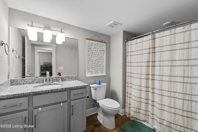 bathroom with hardwood / wood-style flooring, vanity, and toilet