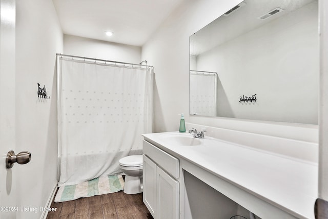 full bathroom with wood-type flooring, toilet, shower / tub combo, and vanity