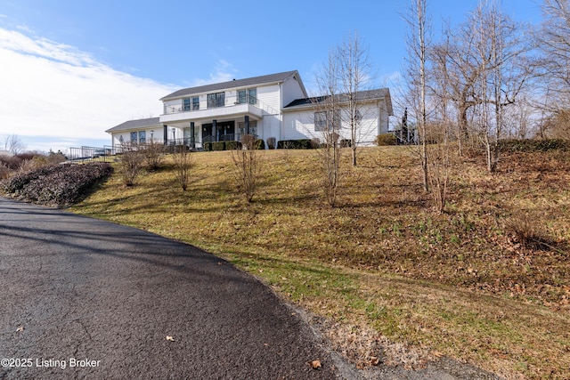 view of front of house with a front yard and a balcony