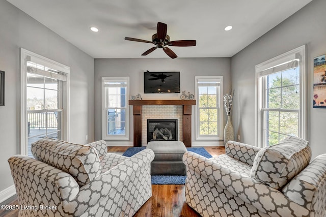 living room with wood finished floors, baseboards, recessed lighting, ceiling fan, and a glass covered fireplace