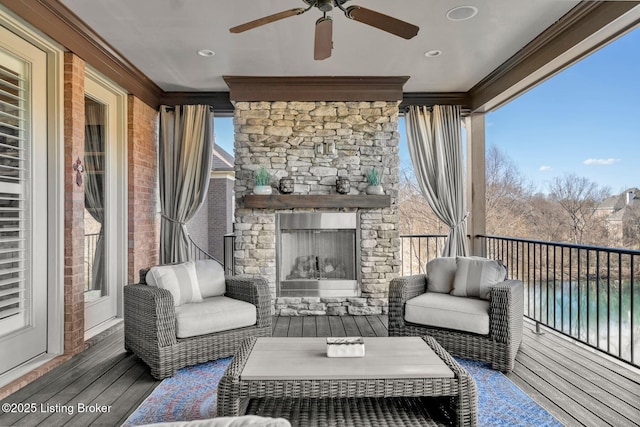 wooden terrace with a ceiling fan and an outdoor living space with a fireplace