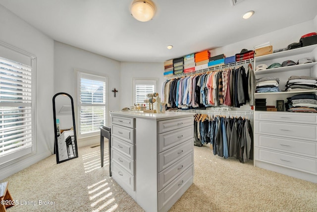 spacious closet featuring light colored carpet