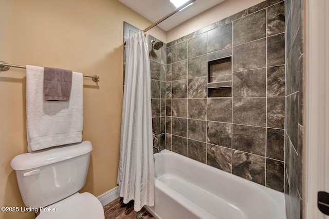 bathroom featuring toilet and shower / bath combination with curtain