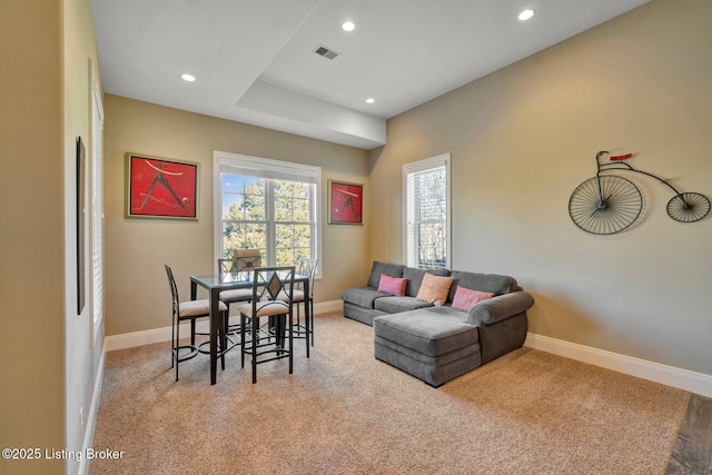 living area featuring recessed lighting, visible vents, baseboards, and light carpet