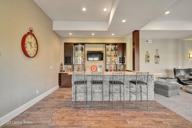 bar featuring visible vents, baseboards, light wood-style flooring, recessed lighting, and indoor wet bar